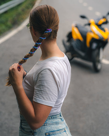 Female motorcyclist tightening her Rip Tie Hair Tie ponytail holder before riding on her motorcycle.